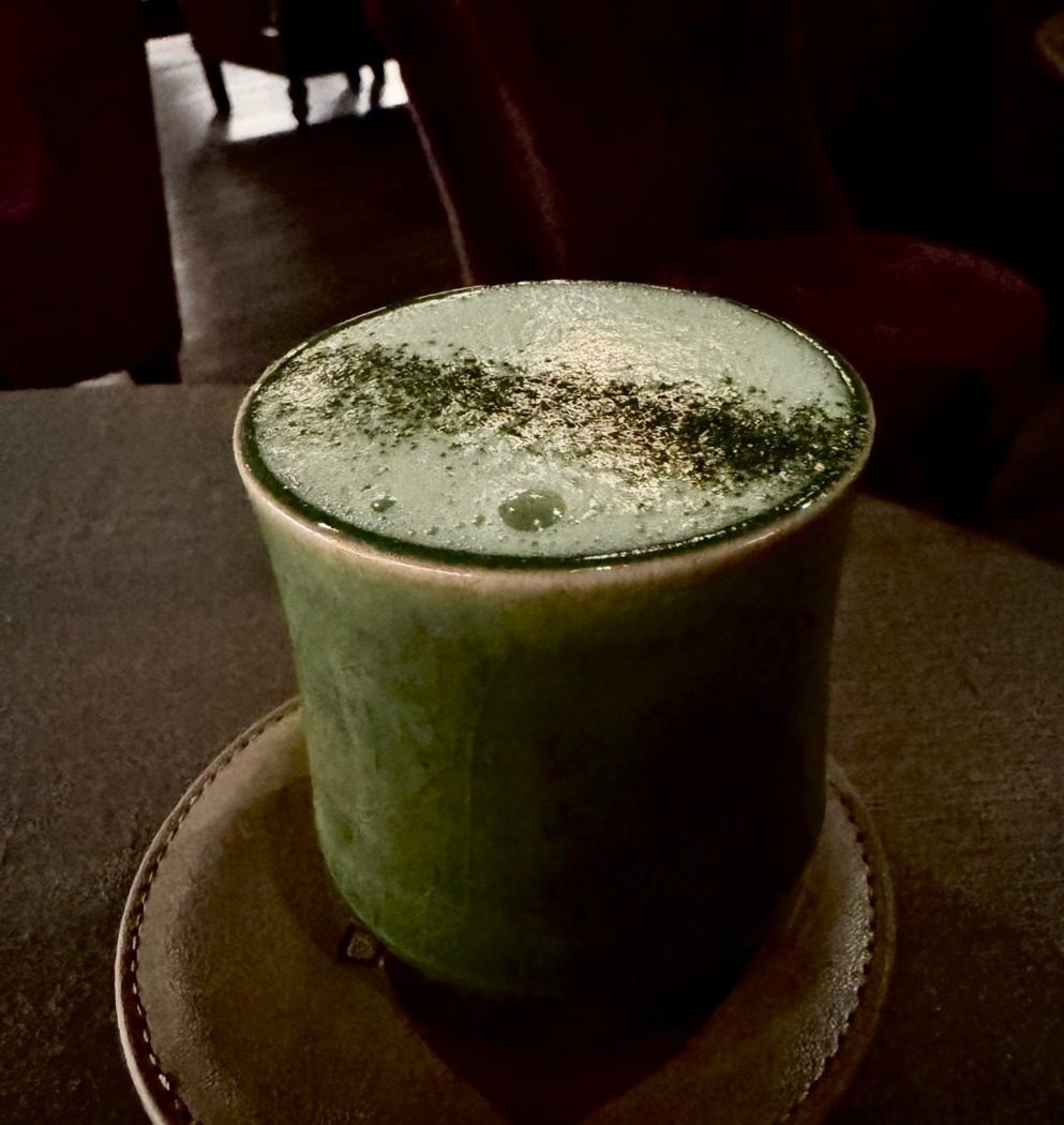 Matcha cocktail in a ceramic cup on a leather coaster